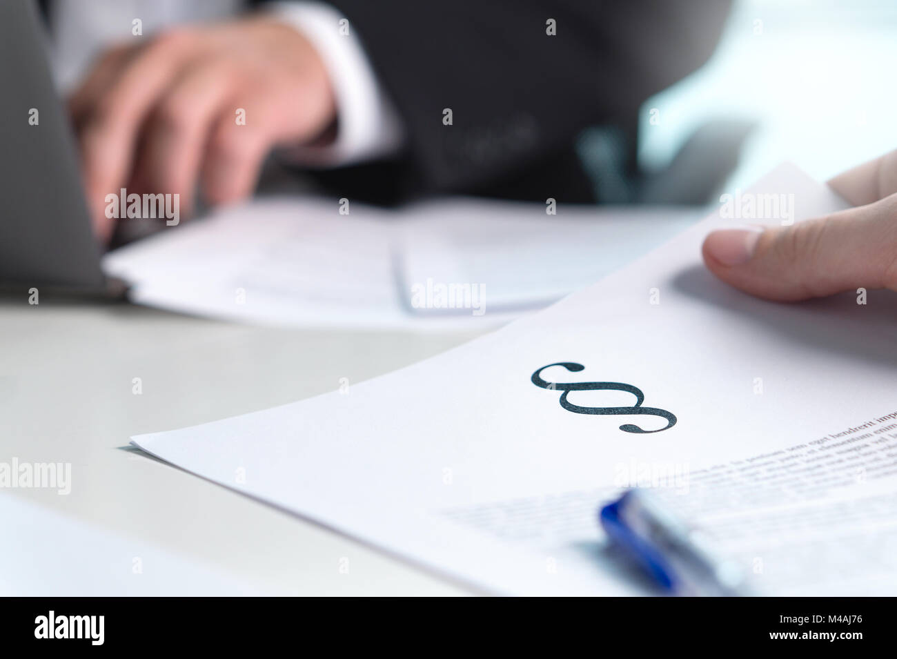 Persone in diritto impresa avente riunione. Avvocato fornendo consulenza legale per un client in ufficio. Uomo in possesso di una carta con una sezione di segno. Foto Stock