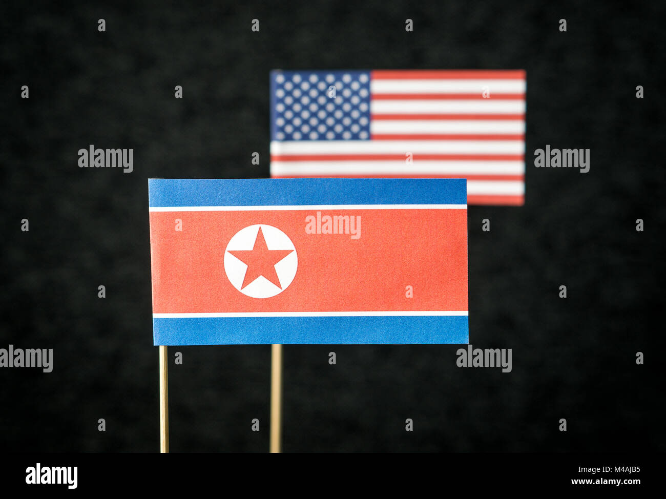 Bandiera della Corea del Nord e gli Stati Uniti d'America (USA) costituito da carta sul bastone di legno contro uno sfondo scuro. Foto Stock