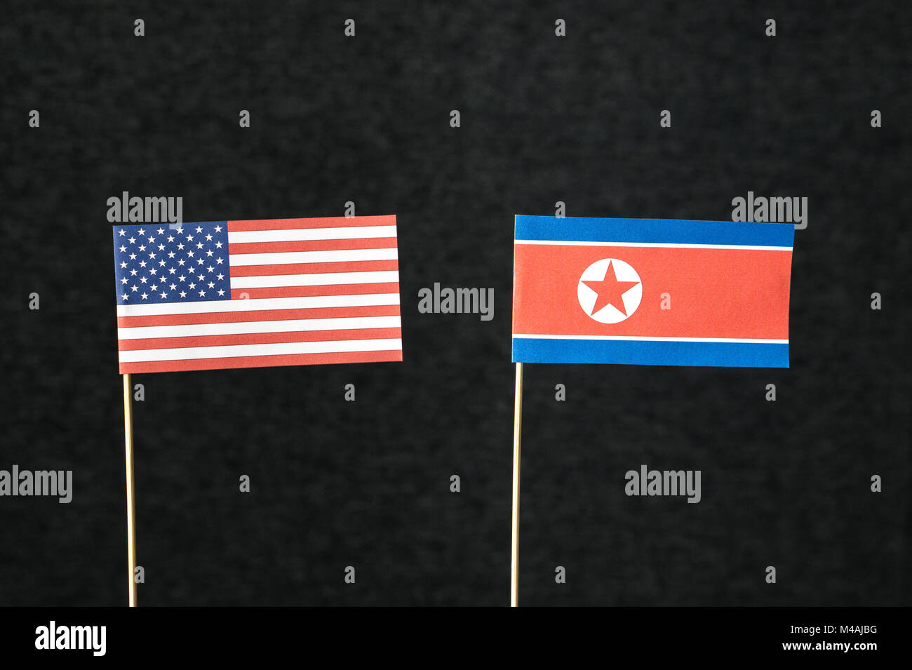Bandiera degli Stati Uniti d'America (USA) e la Corea del Nord costituito da carta sul bastone di legno contro uno sfondo scuro. Foto Stock