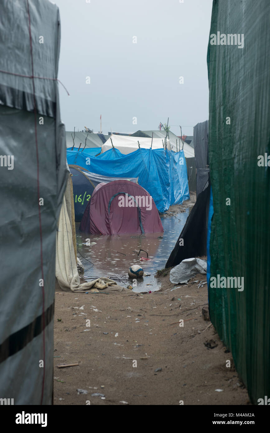 'Streets' di Calais rifugiato & inmigrant camp cosiddetta giungla dopo due giorni di pioggia intensa. Piscine di fango e sono in tutto il luogo. Foto Stock