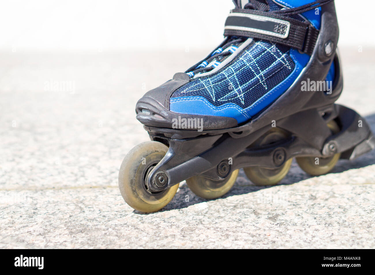 Chiudere fino a pattino a rotelle. Rollerskates e pattini in linea sul cemento e asfalto in città. Foto Stock