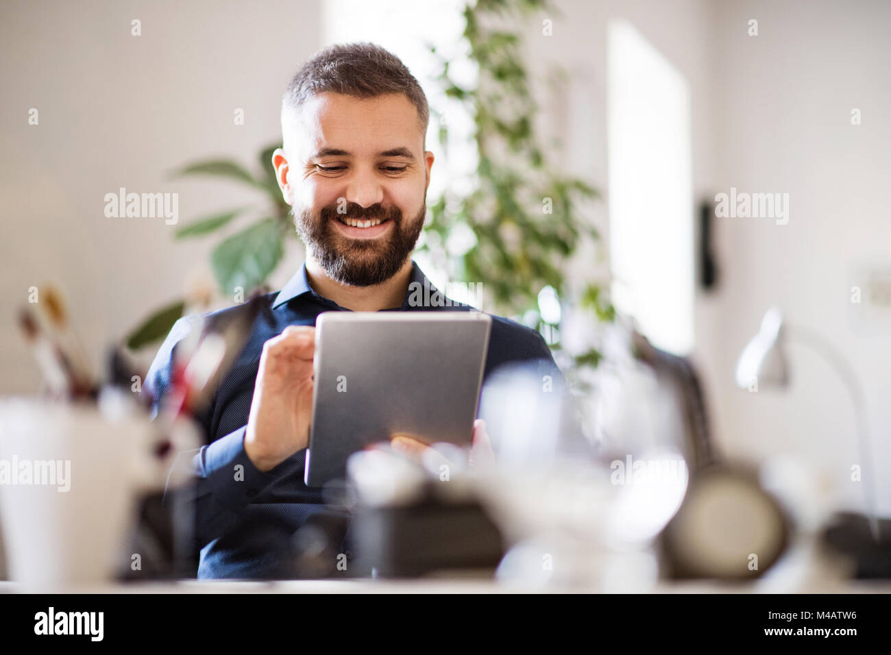 Imprenditore con tablet nel suo ufficio. Foto Stock
