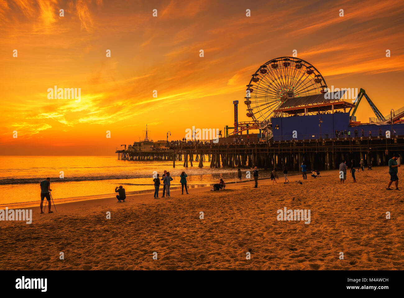 I visitatori godere il tramonto sopra Santa Monica Pier a Los Angeles Foto Stock