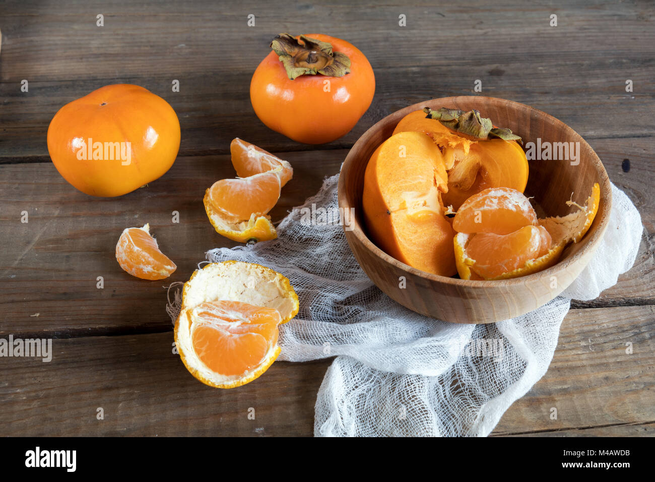 Fresche cachi e mandarini frutti nel recipiente Foto Stock