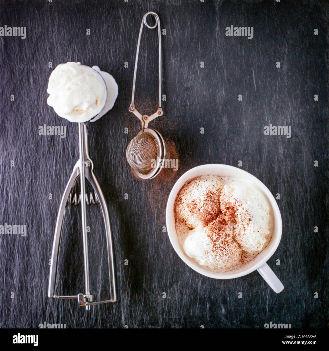 Gelato alla vaniglia e scoop su una lastra di pietra Foto Stock