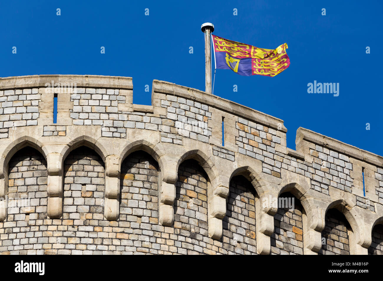 Il Royal Standard battenti bandiera su / da un pennone / pole al Castello di Windsor, Regno Unito. È volato a residenze reali solo quando il sovrano è presente. Foto Stock