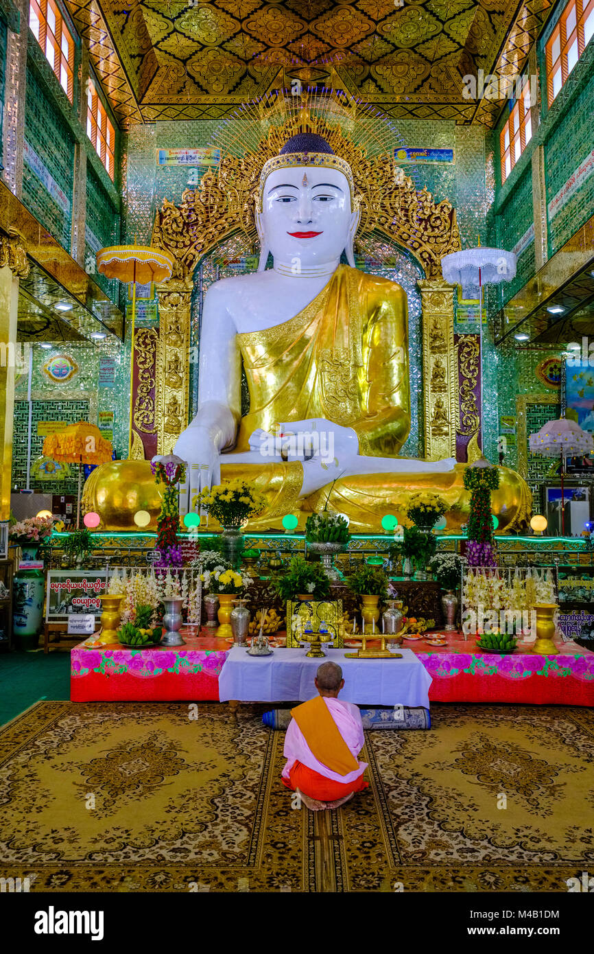 Una donna è in preghiera di fronte alla grande statua del Buddha in presto U Ponya Shin Pagoda sulla cima della collina di Sagaing Foto Stock
