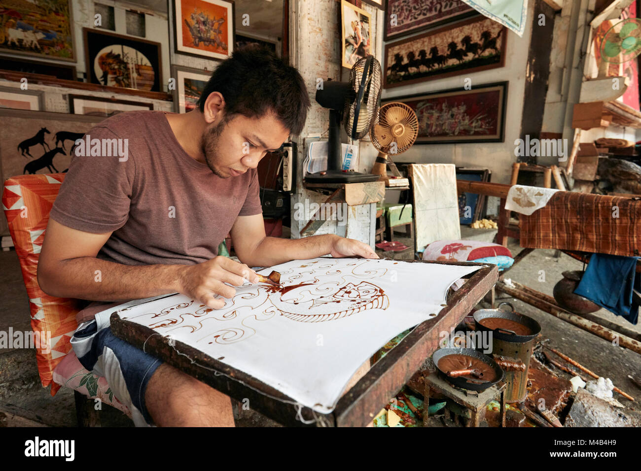 Un creatore di batik lavora nel suo laboratorio a Batik seno, una galleria a Yogyakarta, Java, Indonesia. Foto Stock