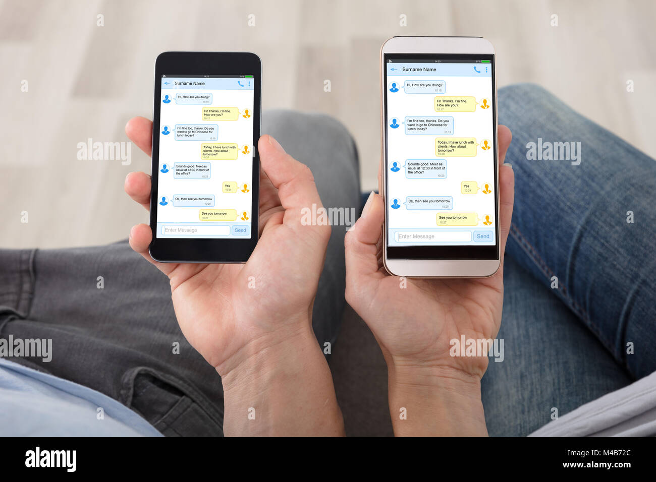 Close-up del giovane mano sta tenendo i telefoni cellulari che mostra i messaggi sullo schermo Foto Stock