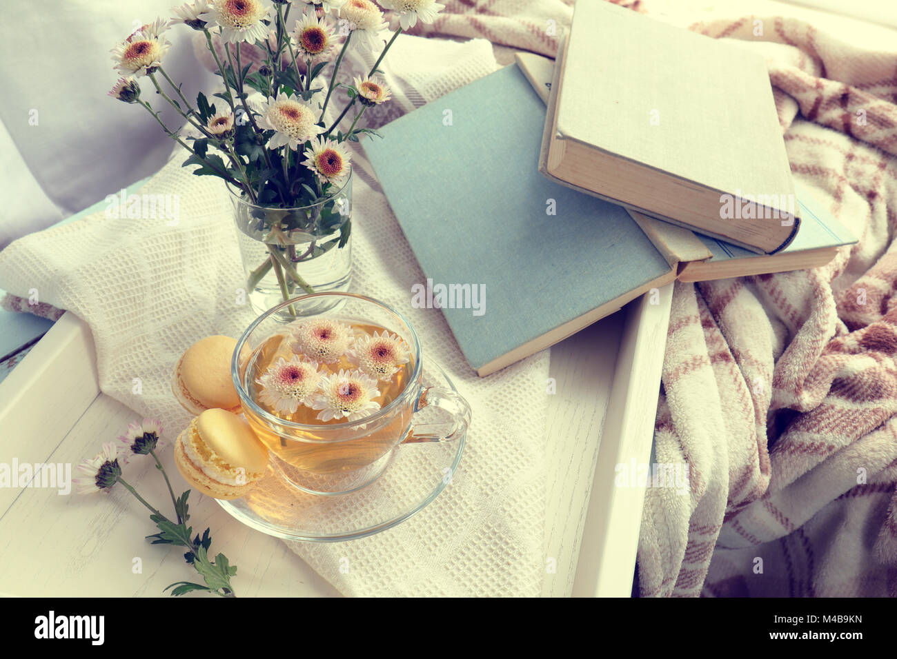 Tazza di tè, amaretti, crisantemo fiori e libri Foto Stock