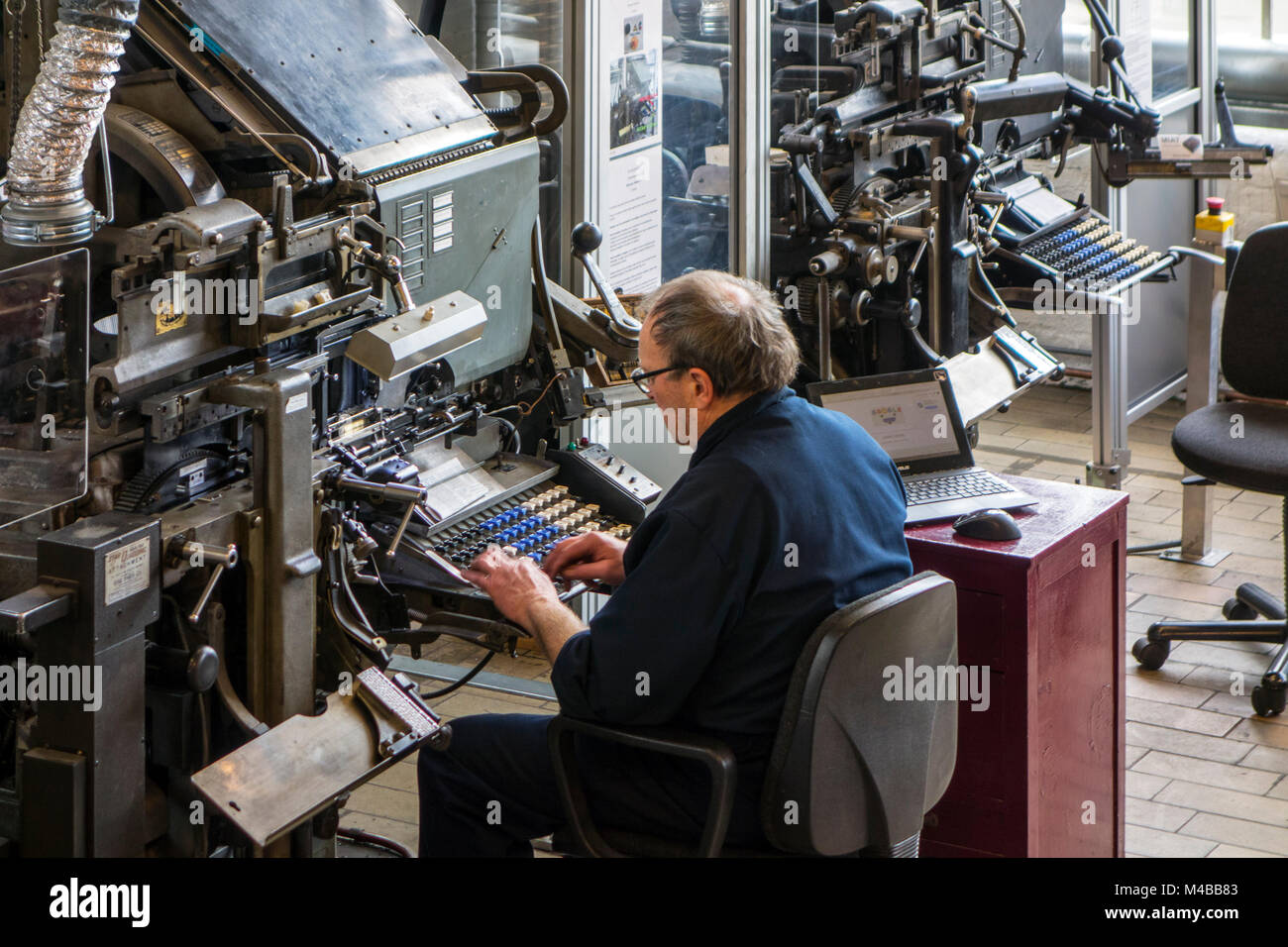 Linotype macchina operatore immette il testo su un 90-tastiera dei caratteri per la stampa di business Foto Stock