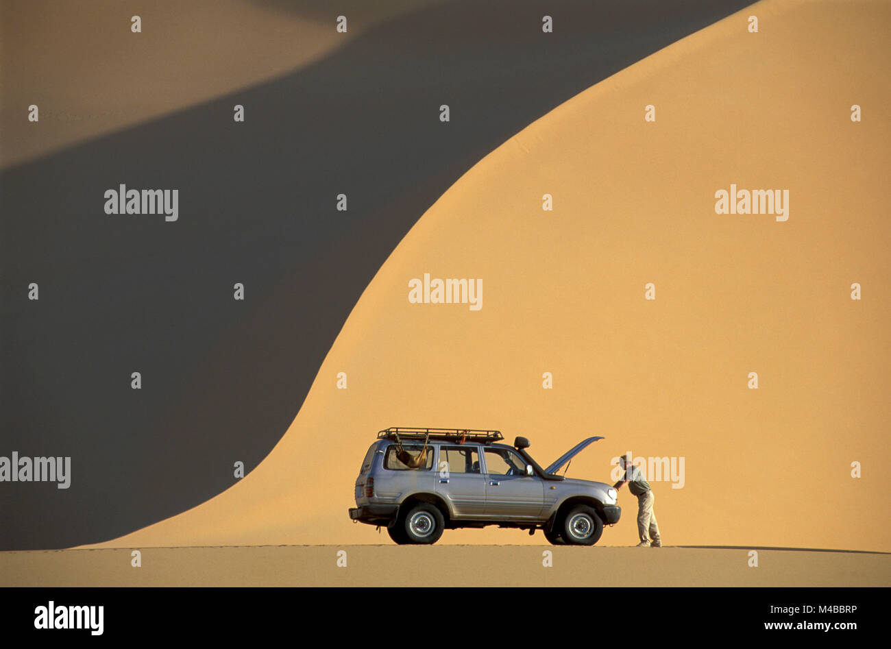 In Algeria. Djanet. Deserto del Sahara. Erg Admer. Il turista. Uomo con rotte SUV, auto 4WD. Foto Stock