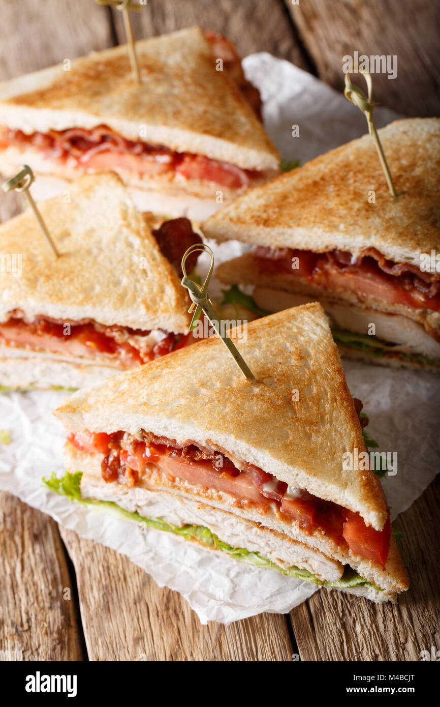Club sandwich con la Turchia, bacon, formaggio e verdure vicino sul piano verticale. Foto Stock