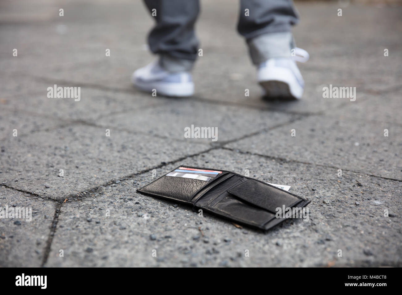 Uomo che cammina dopo aver perso il suo portafoglio su strada Foto Stock