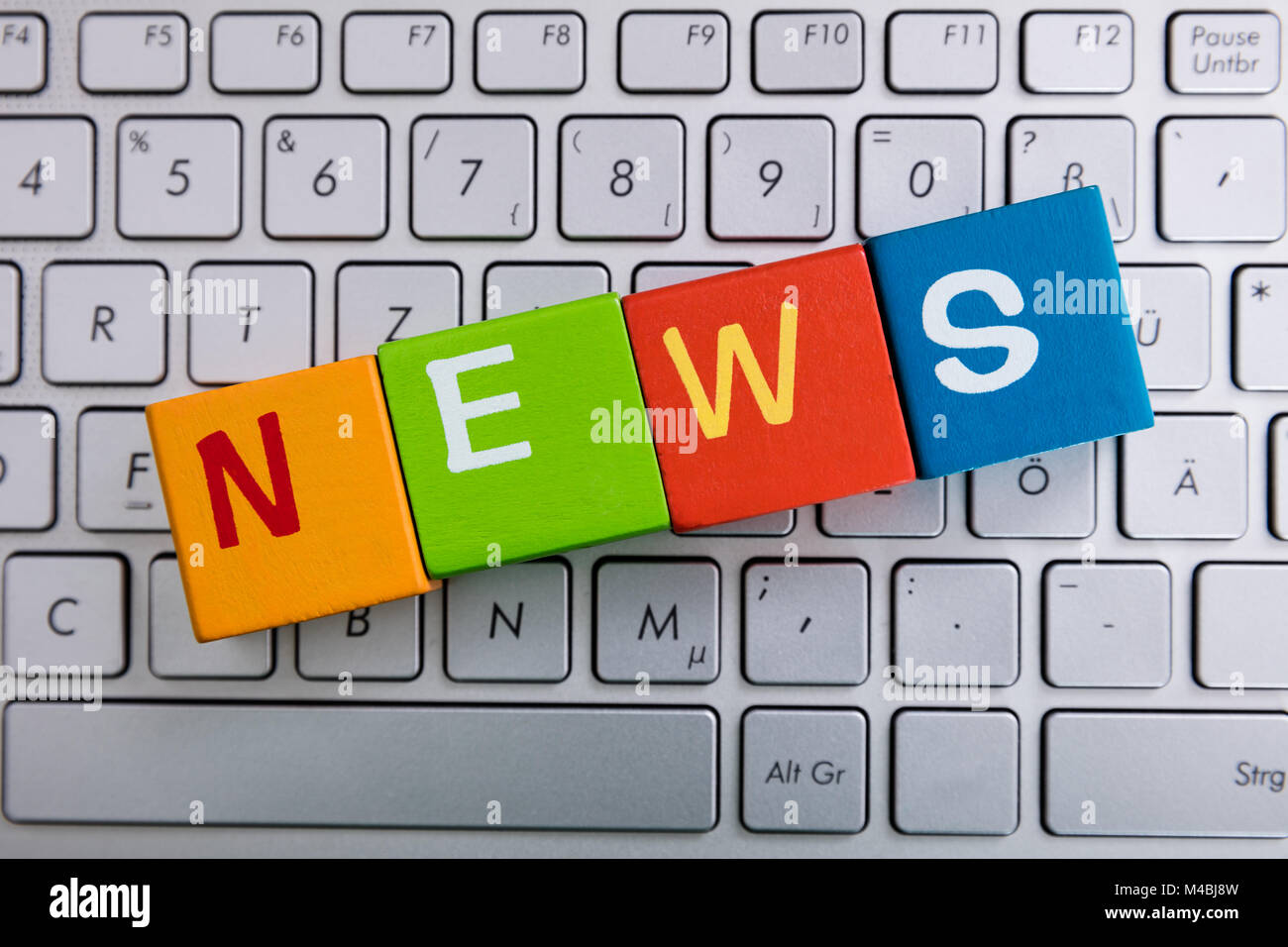 News il testo su cubi colorati sulla tastiera del notebook Foto Stock