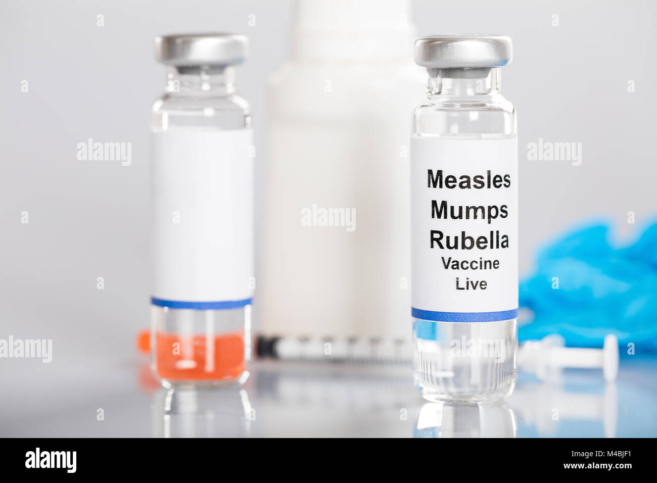 Close-up di morbillo parotite il vaccino contro la rosolia con siringa e medicinali Foto Stock