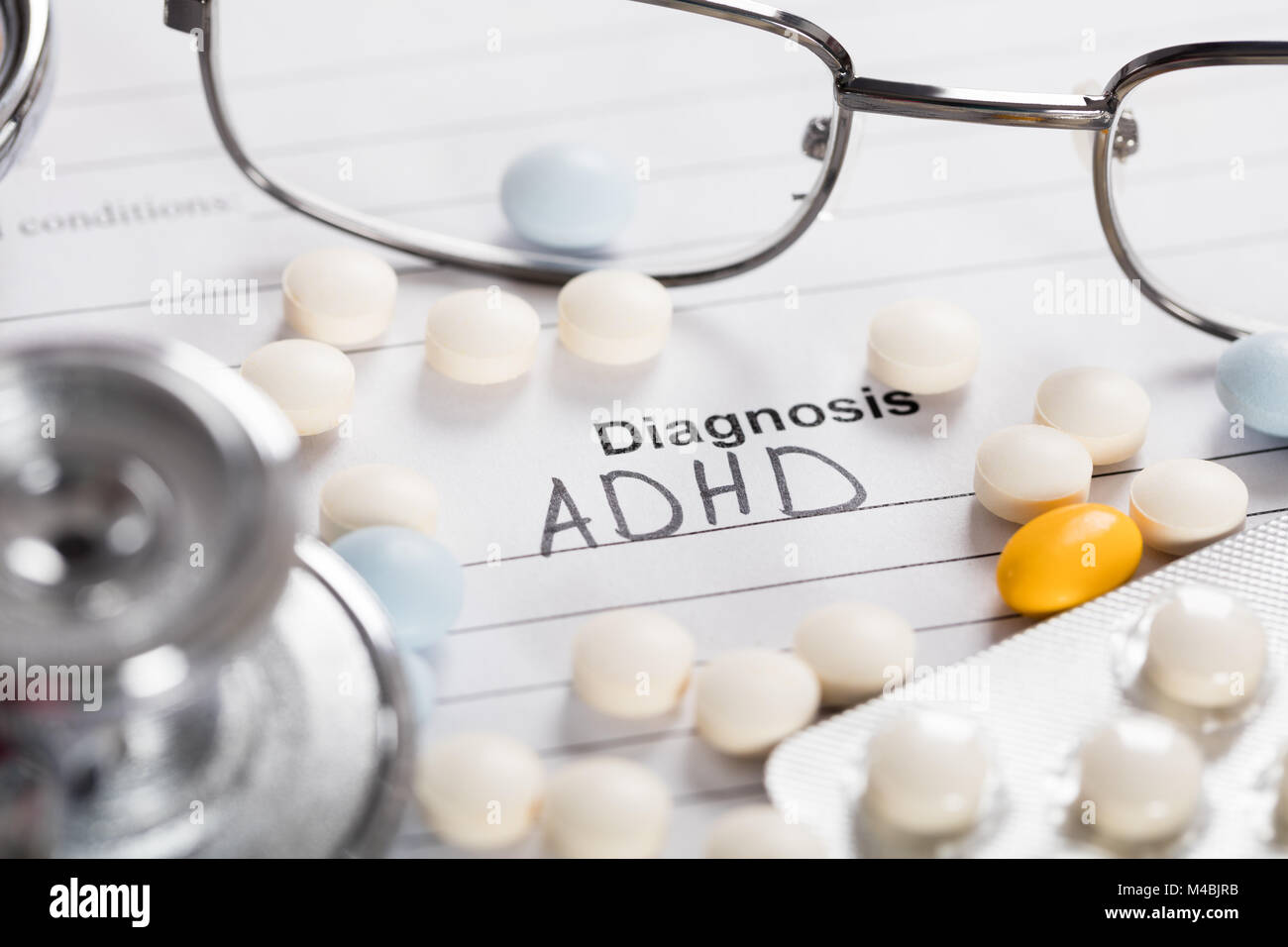 Pills;bicchieri e stetoscopio con testo diagnosi ADHD su carta Foto Stock