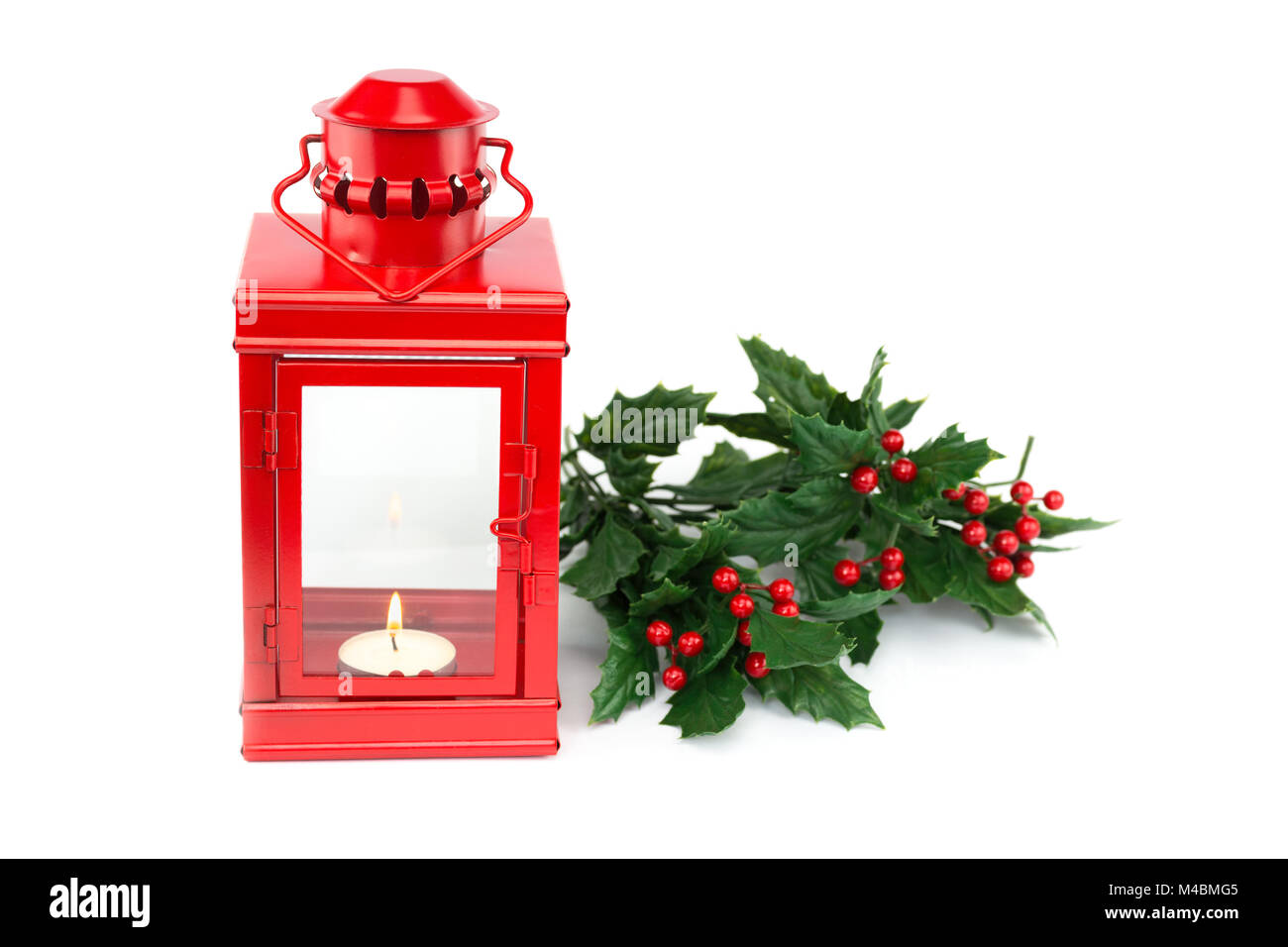Lanterna rossa con tealight holly ramoscelli e bacche Foto Stock