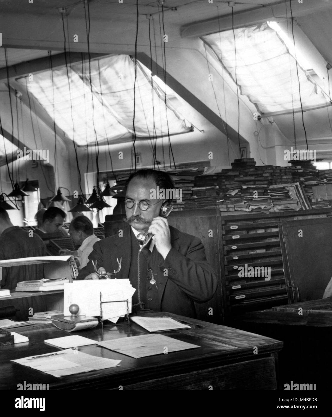 Uomo al telefono in ufficio,1940s,posizione esatta sconosciuto,Germania Foto Stock