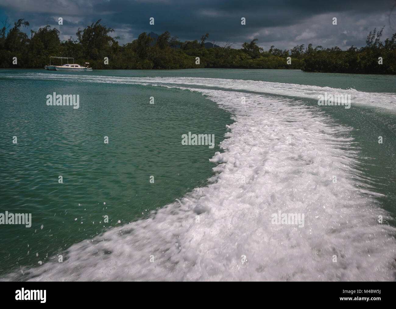 Schiumoso a sentieri di acqua lasciata dal motoscafo nel suo percorso, Touesrok, Mauritius Foto Stock