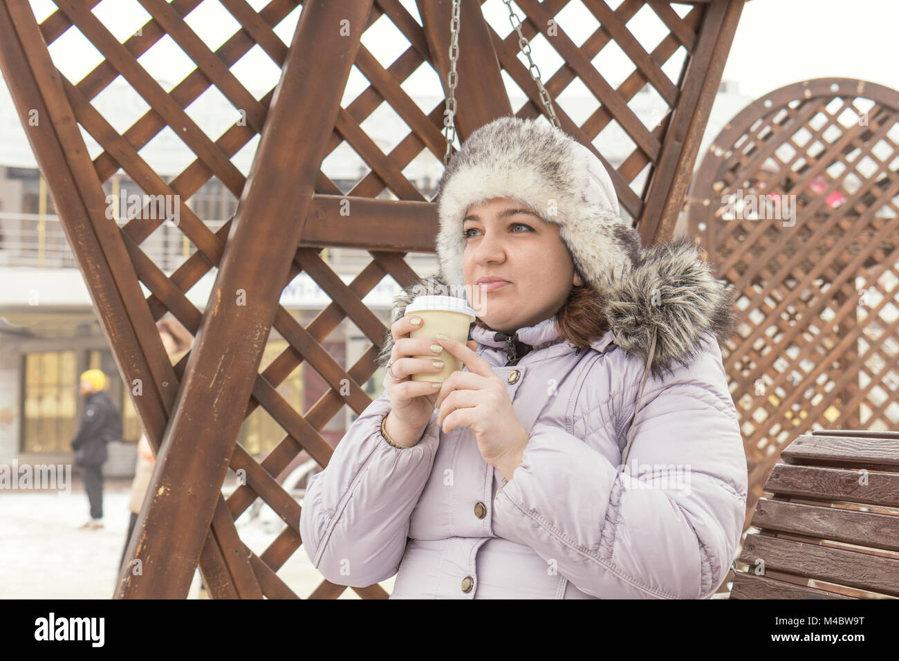 Giovane donna è di bere il caffè sulla strada Foto Stock