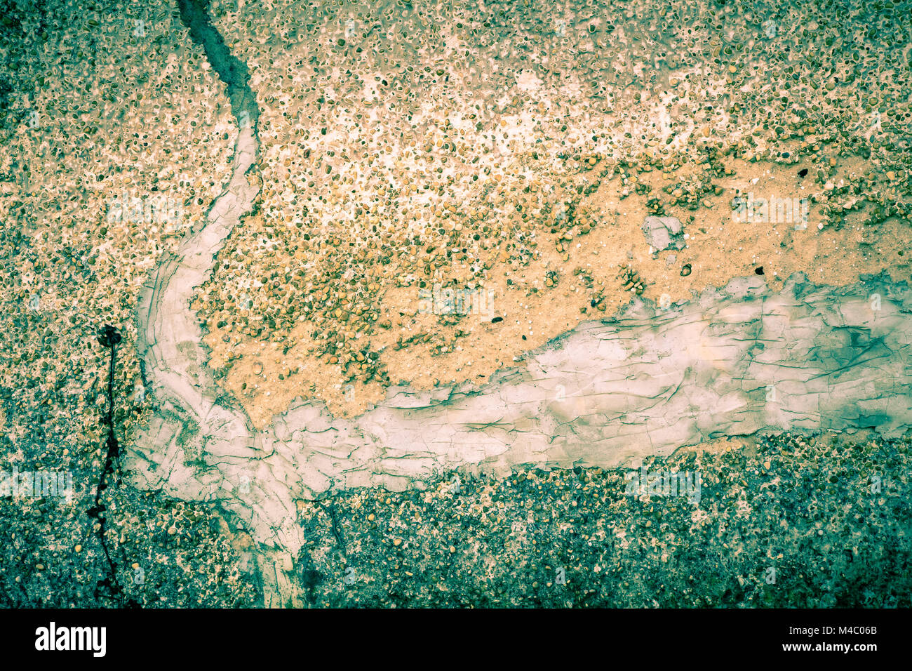 Cemento ruvida texture con ciottoli e crepe con patch Foto Stock