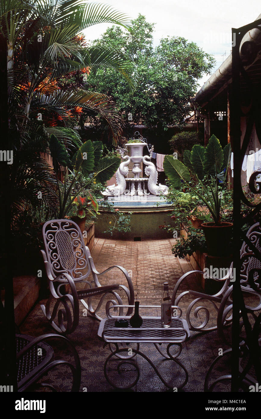 Incantevole patio con sedie a dondolo, un bellissimo giardino con una fontana e un'architettura coloniale spagnola ristrutturata guesthouse, Trinidad, Cuba Foto Stock