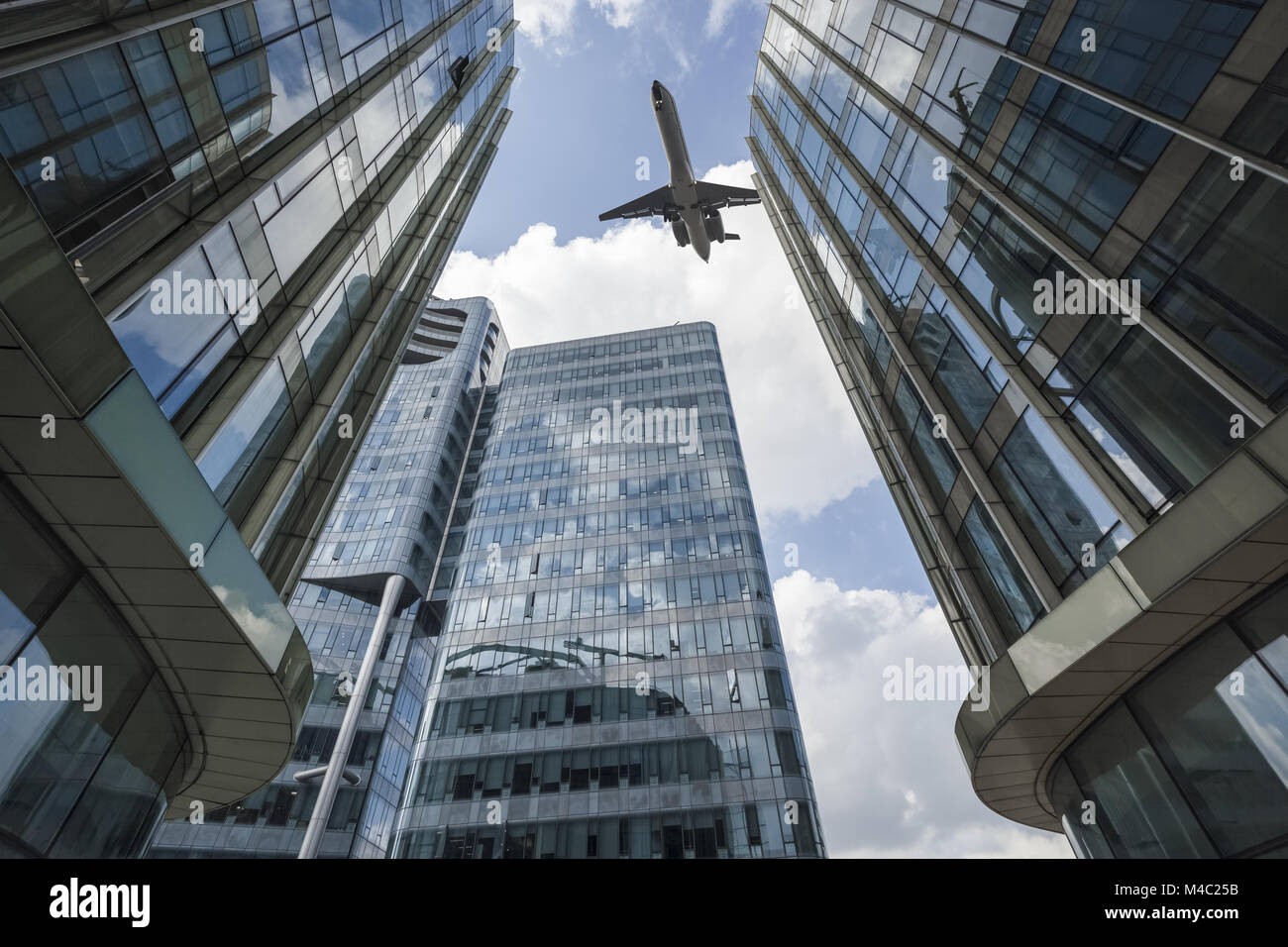 Aereo di linea volò sopra il moderno edificio di vetro Foto Stock
