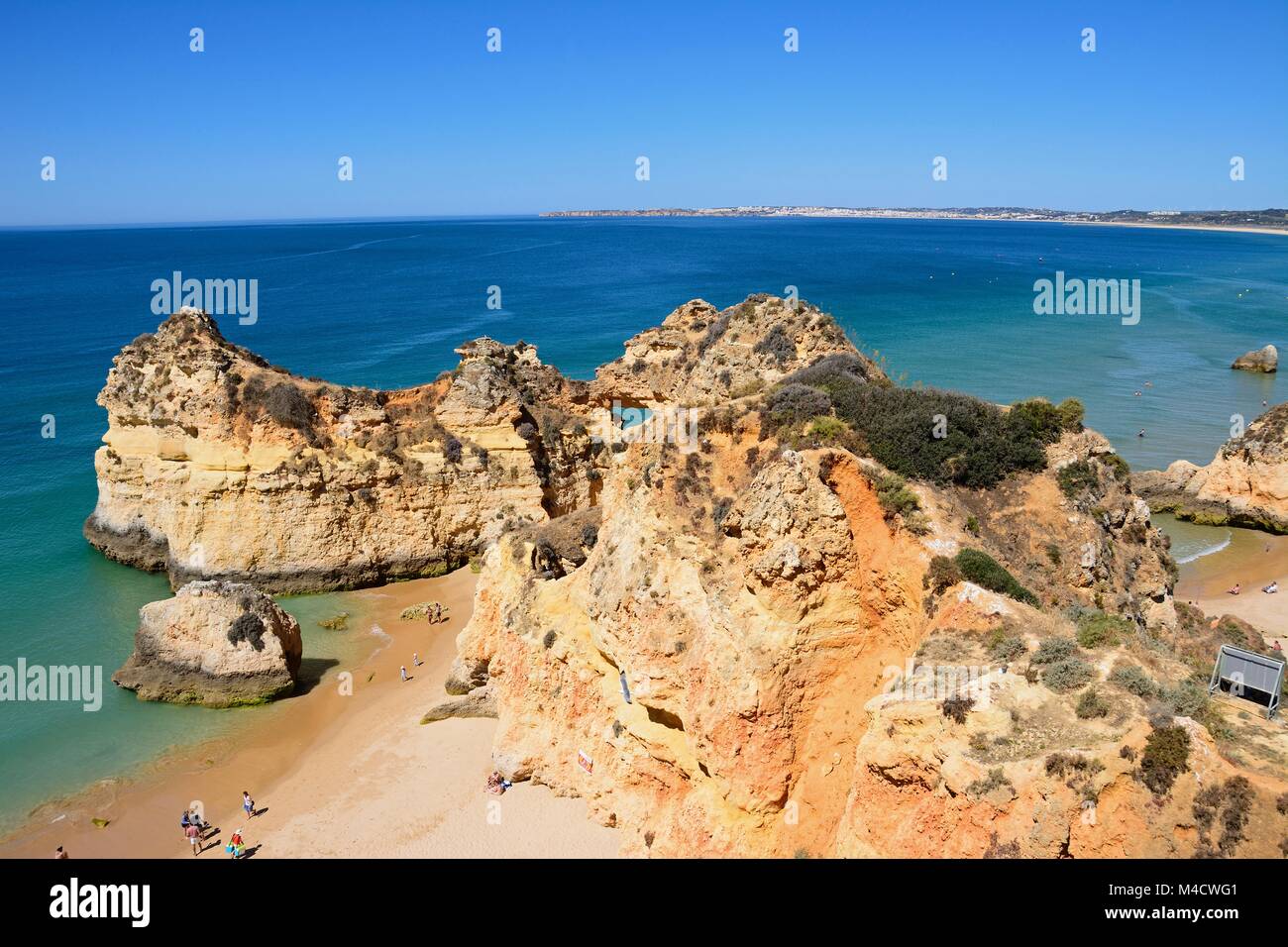 Vista in elevazione della costa rocciosa con turisti rilassati sulla spiaggia Praia da Rocha, Algarve, Portogallo, dell'Europa. Foto Stock