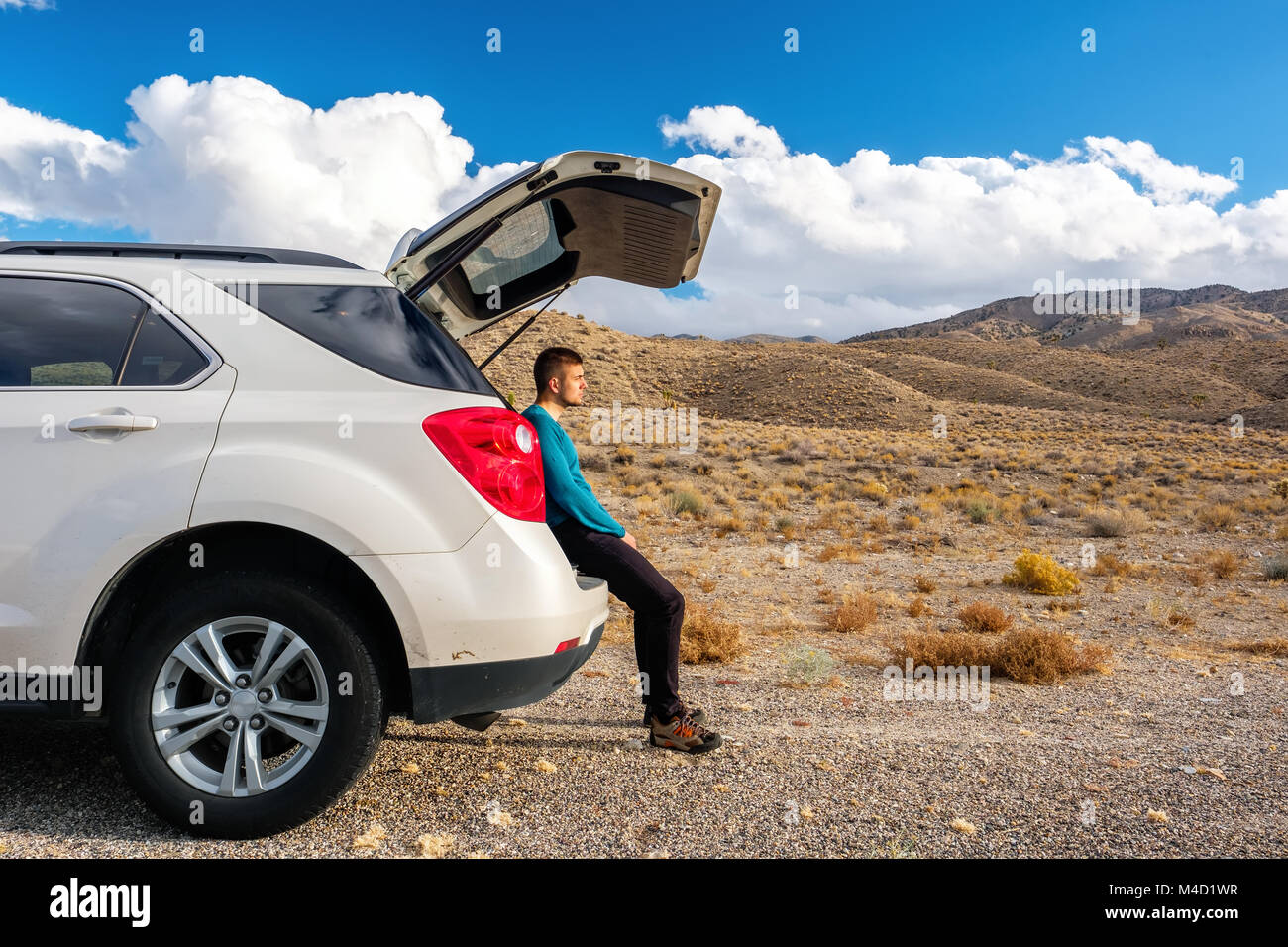 Uomo seduto nel baule auto autostrada a spalla Foto Stock