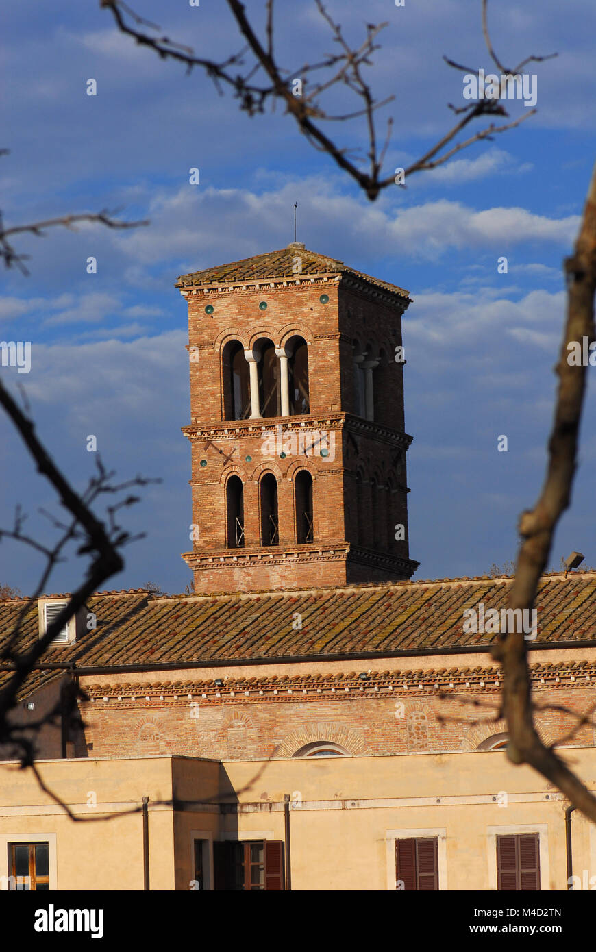 San Bartolomeo all'Isola antico campanile medievale nel centro storico di Roma, si vede attraverso i rami degli alberi Foto Stock