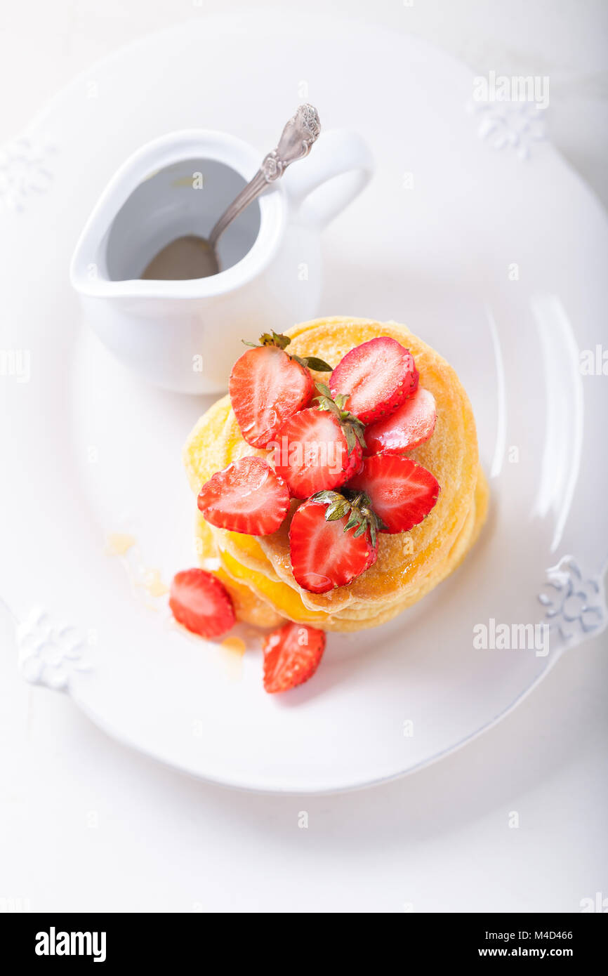 Pila di frittelle dolci con fragola e miele. Foto Stock