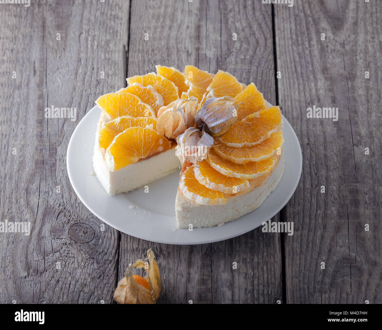 Cheesecake decorata con arance e physalis Foto Stock