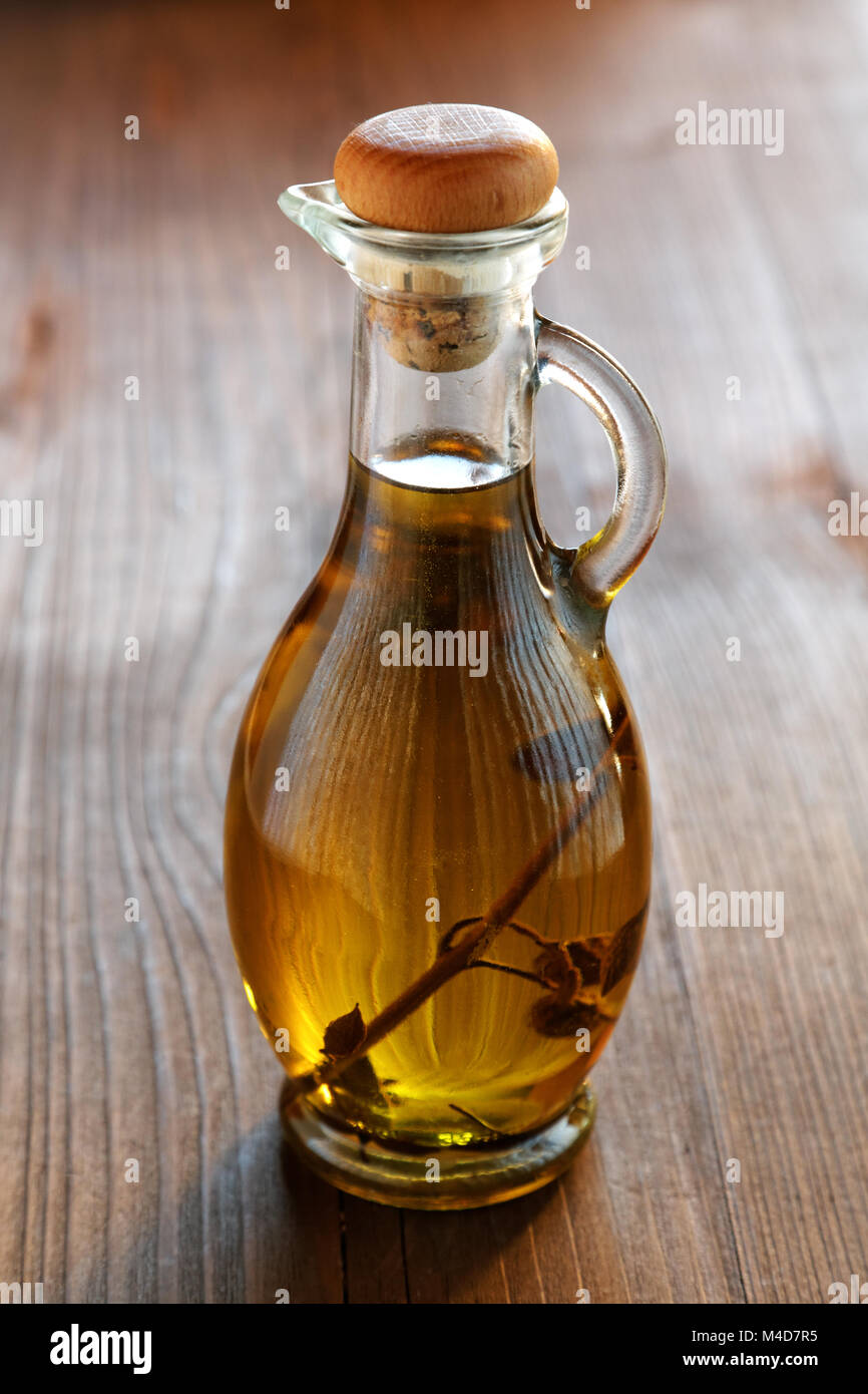 Olio di oliva Bottiglia su un tavolo rustico Foto Stock