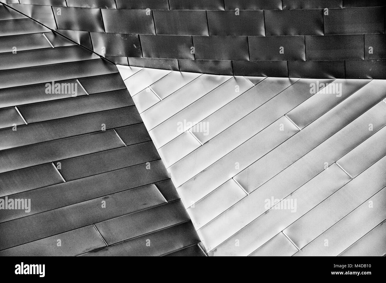 Architettura moderna abstract di metallo lucido pannelli riflettendo la luce che evidenziare una sezione triangolare. Foto Stock