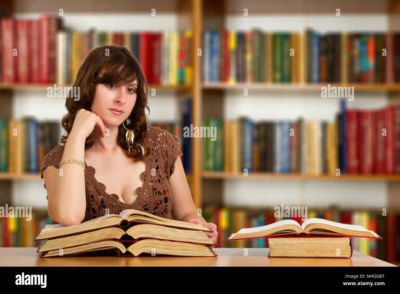 Studente con il libro aperto in lettura che in college library Foto Stock