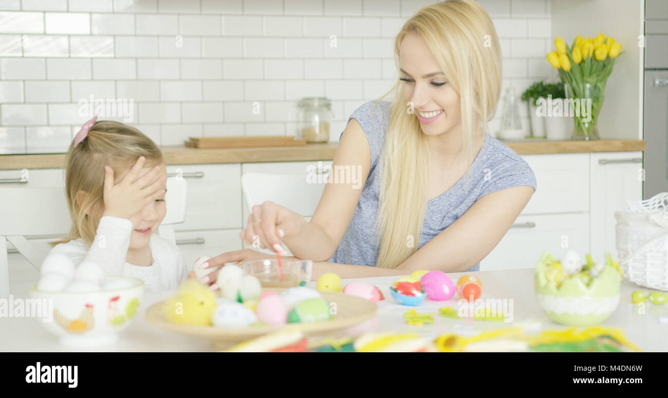 Ridendo famiglia uova di colorazione Foto Stock