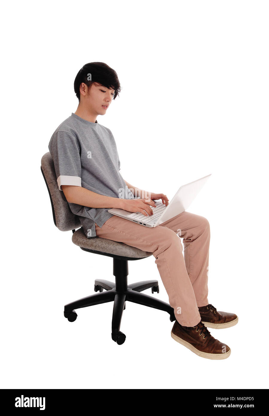 Uomo asiatico digitando al suo computer portatile. Foto Stock