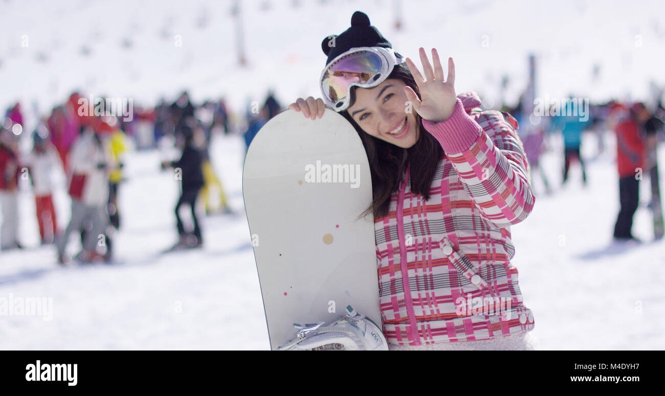 Donna con lo snowboard rilassante in vacanza Foto Stock