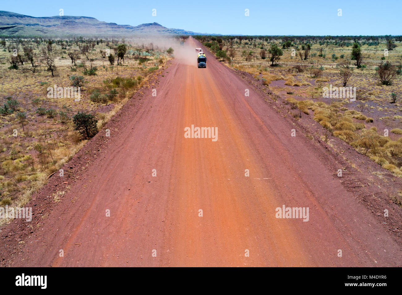 Road train su rosso su strada sterrata in Australian Outback, Wittenoom, Pilbara, Australia occidentale Foto Stock