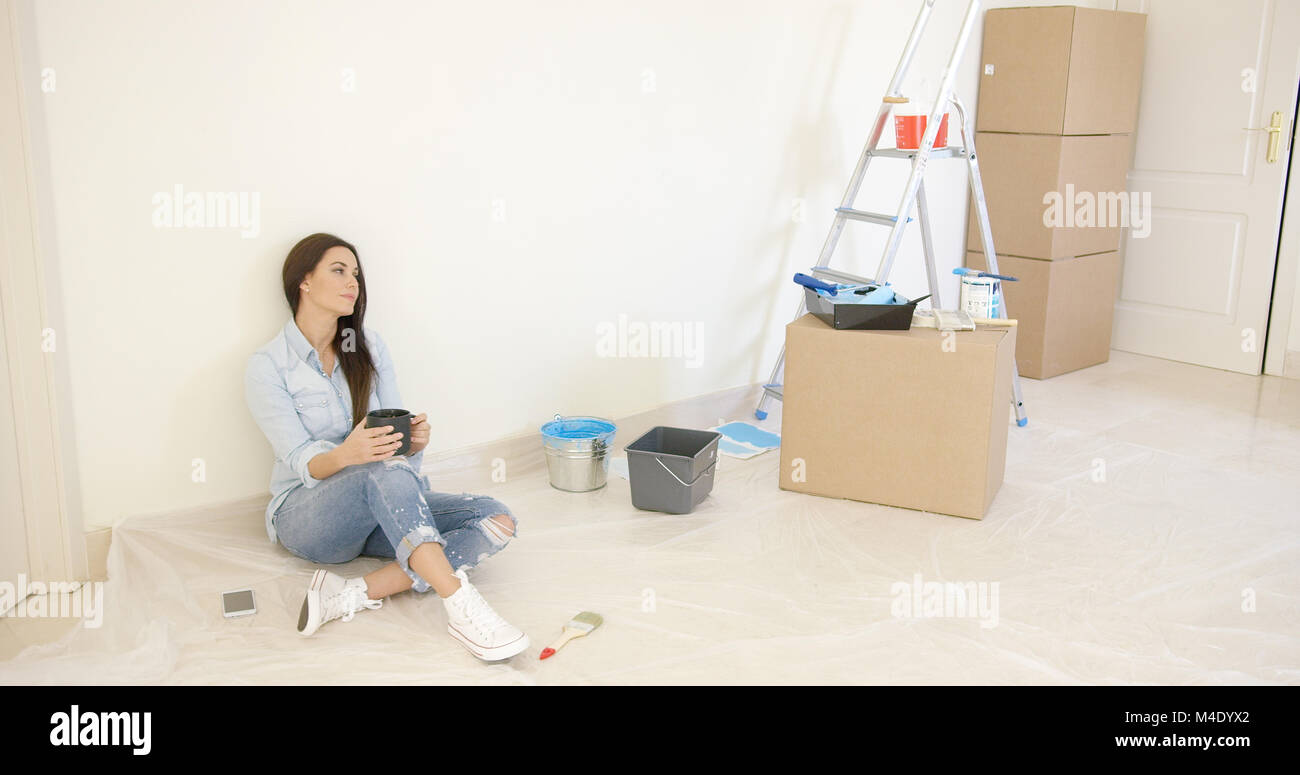 Stanco giovane donna rilassante durante i lavori di rinnovo Foto Stock