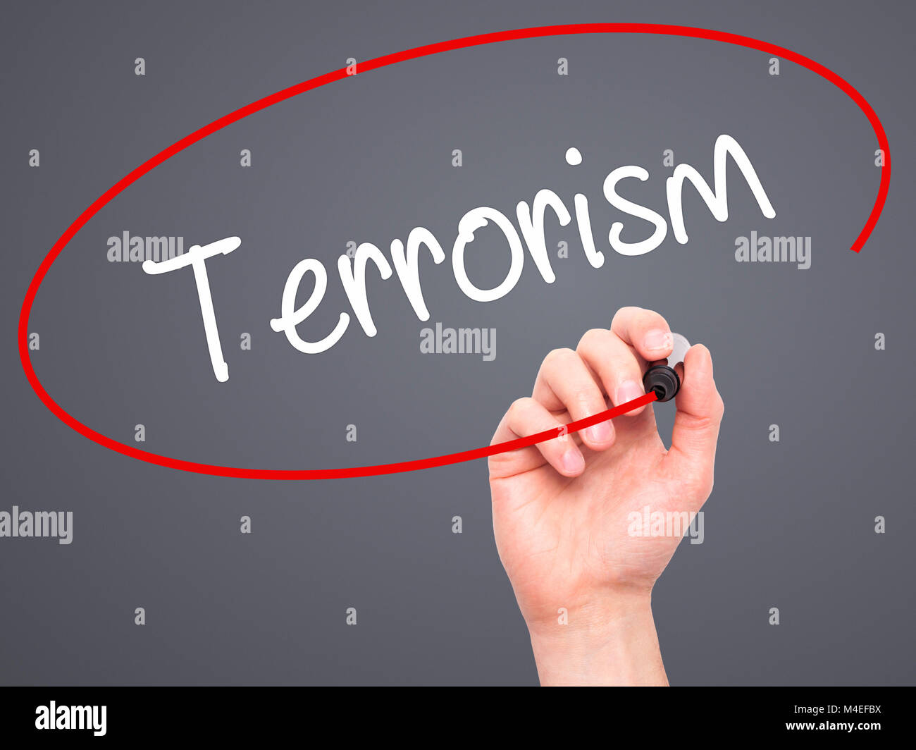 Man mano che scrive il terrorismo con il pennarello nero su schermo visivo Foto Stock