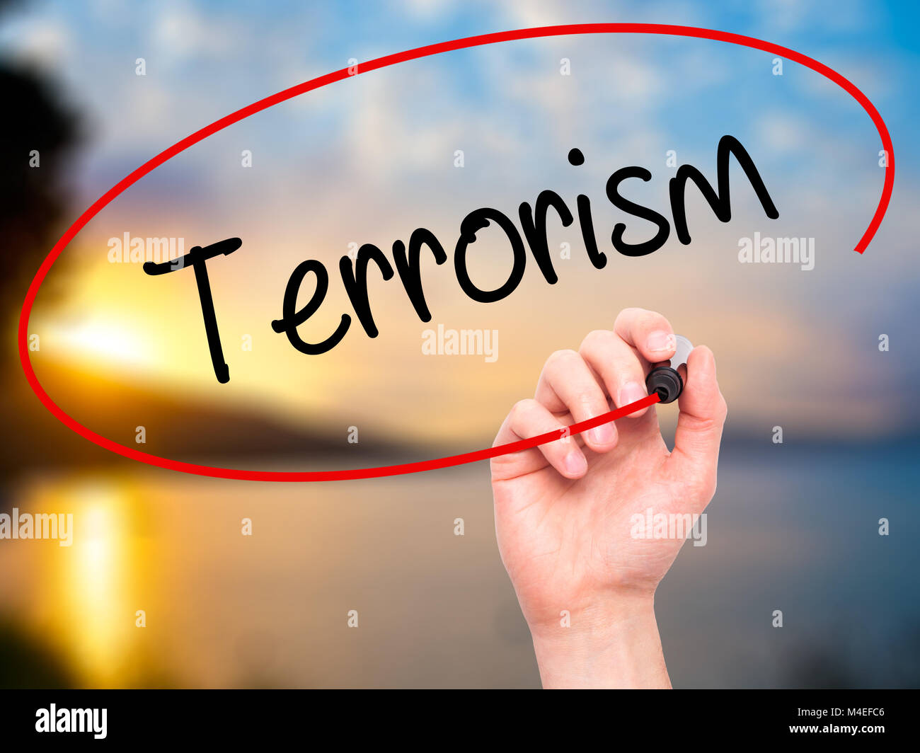 Man mano che scrive il terrorismo con il pennarello nero su schermo visivo Foto Stock