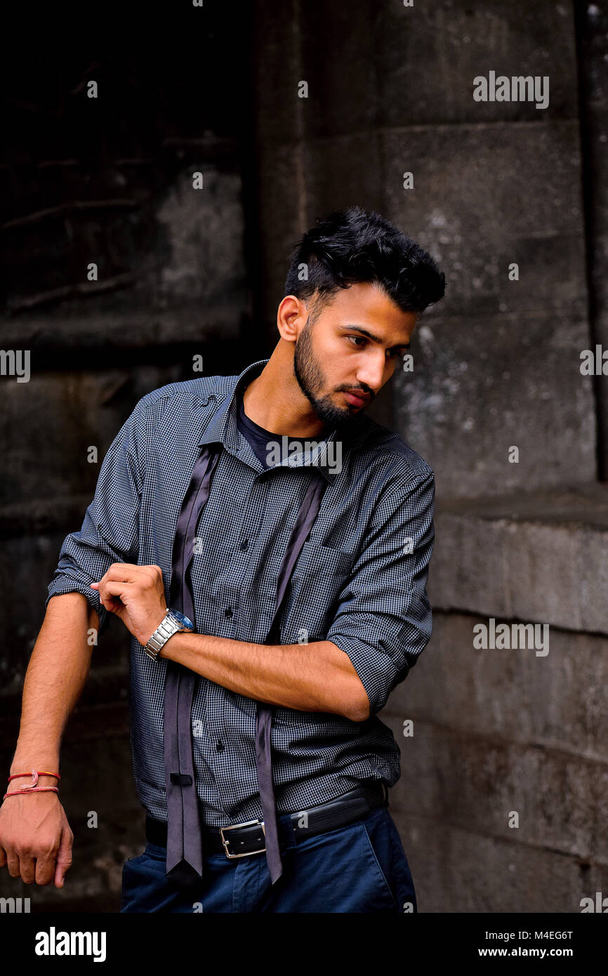 Giovane uomo vestito in camicia formale con slegato black tie di Pune, Maharashtra. Foto Stock