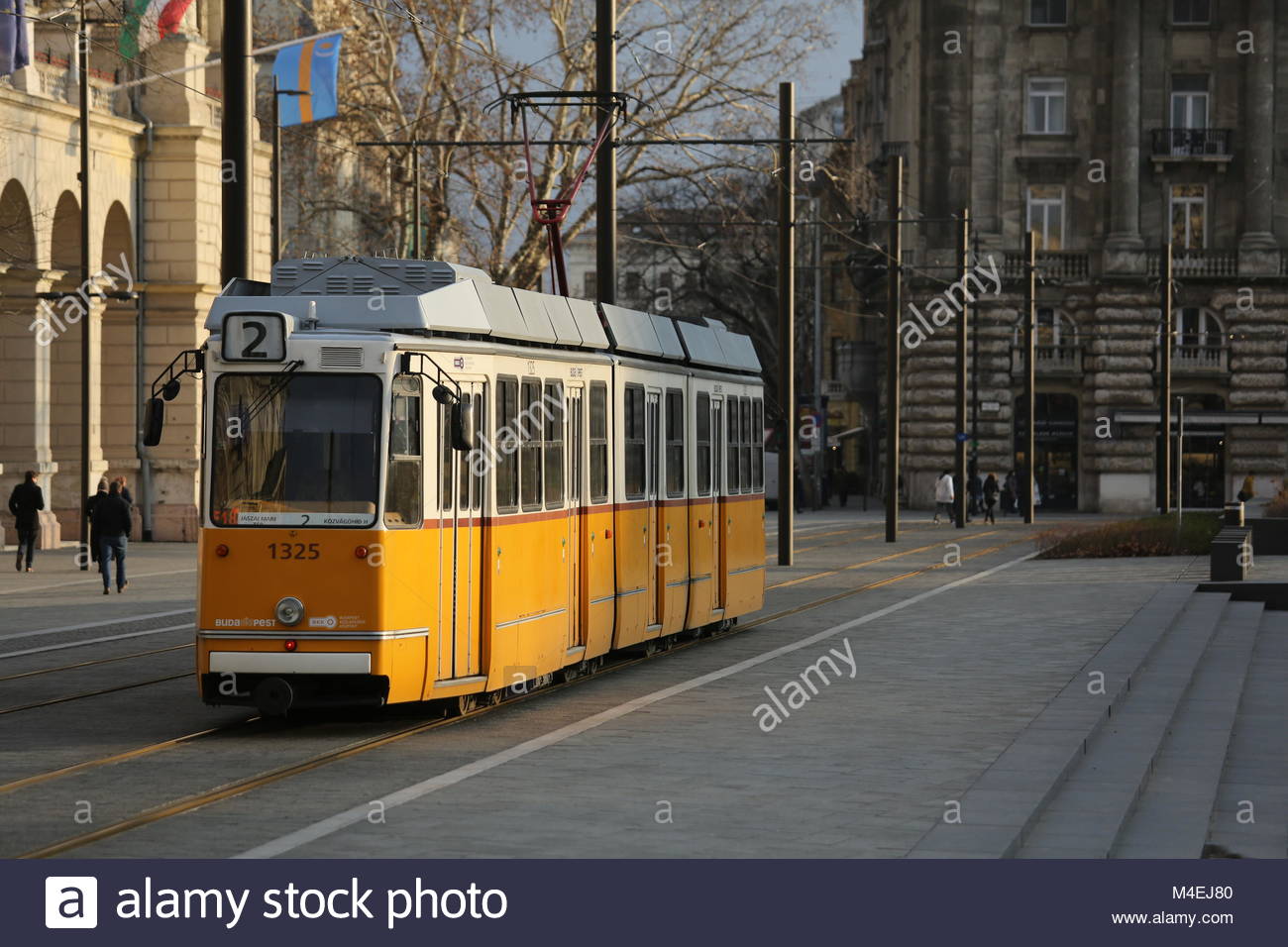 Un giallo il tram passa attraverso una strada principale molto trafficata a Budapest, in Ungheria su una giornata invernale e. Foto Stock