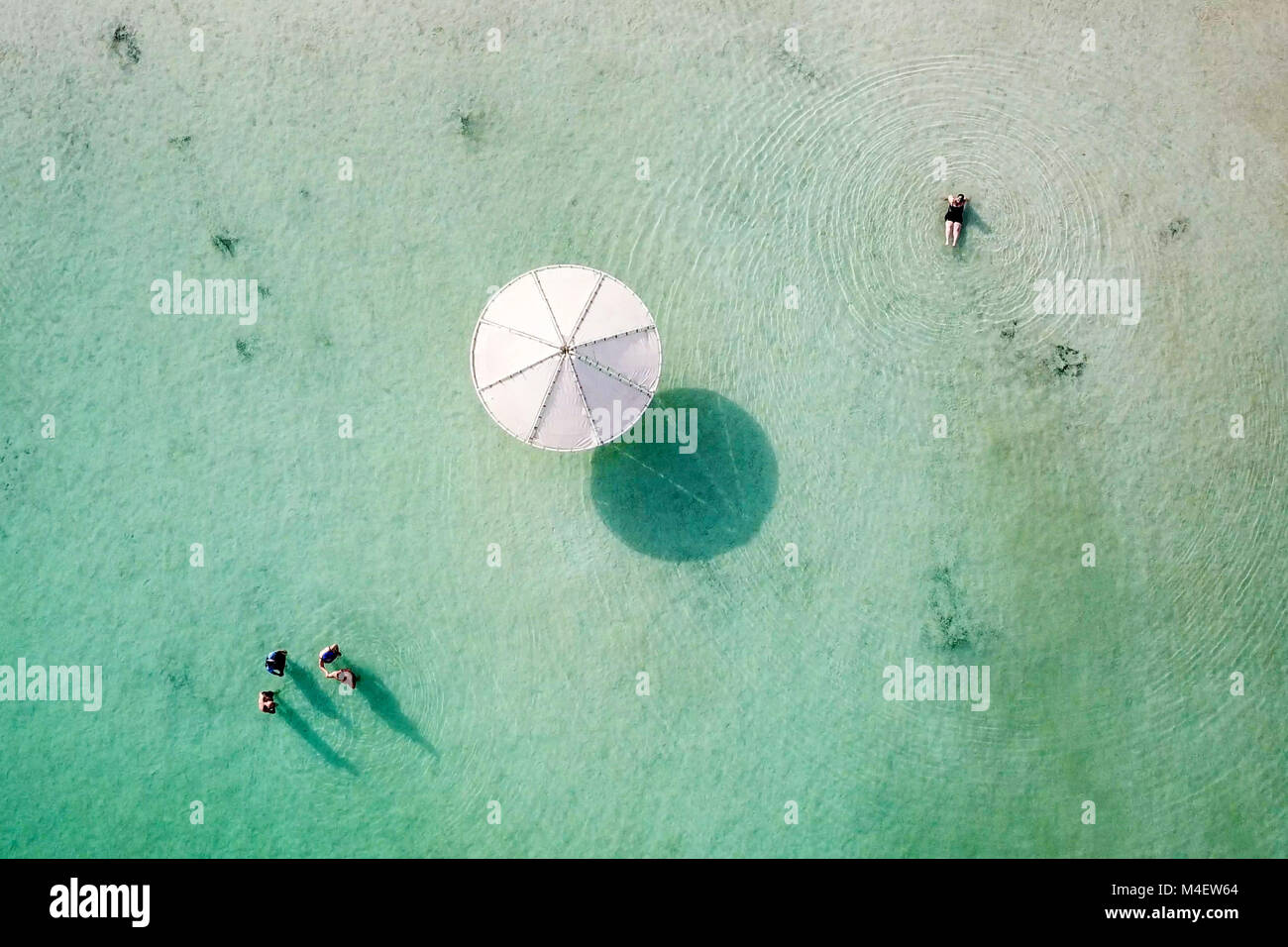 Top down immagine aerea di persone galleggiante in acqua salata del Mar Morto, Israele. Foto Stock