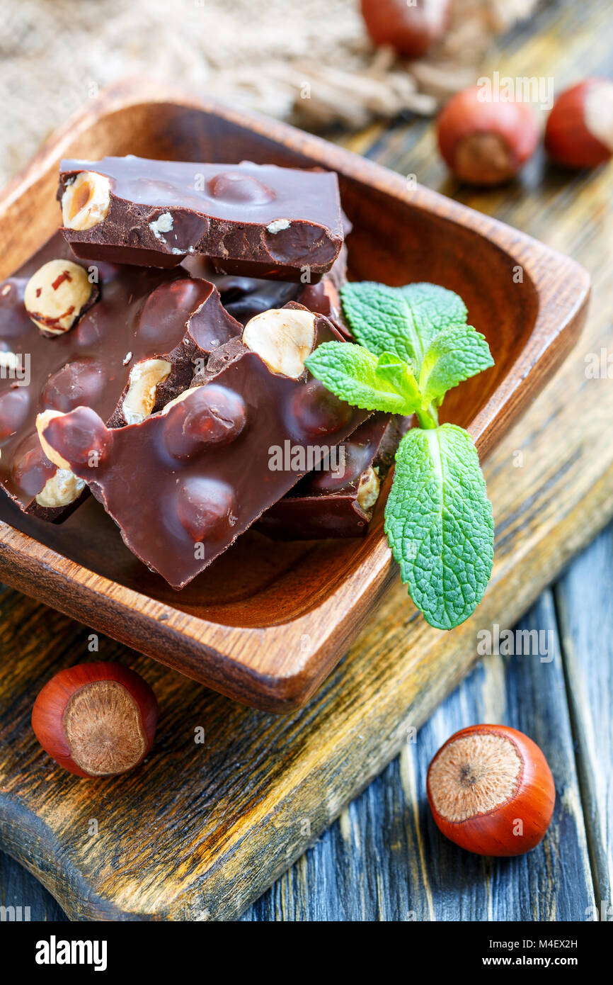 Ciotola di legno con pezzi di cioccolato. Foto Stock