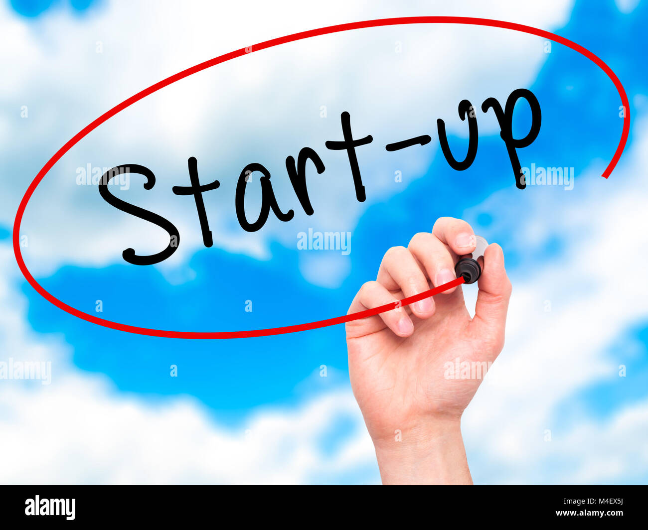 Man mano che scrive di start-up con marcatore sul trasparente scheda di pulizia Foto Stock