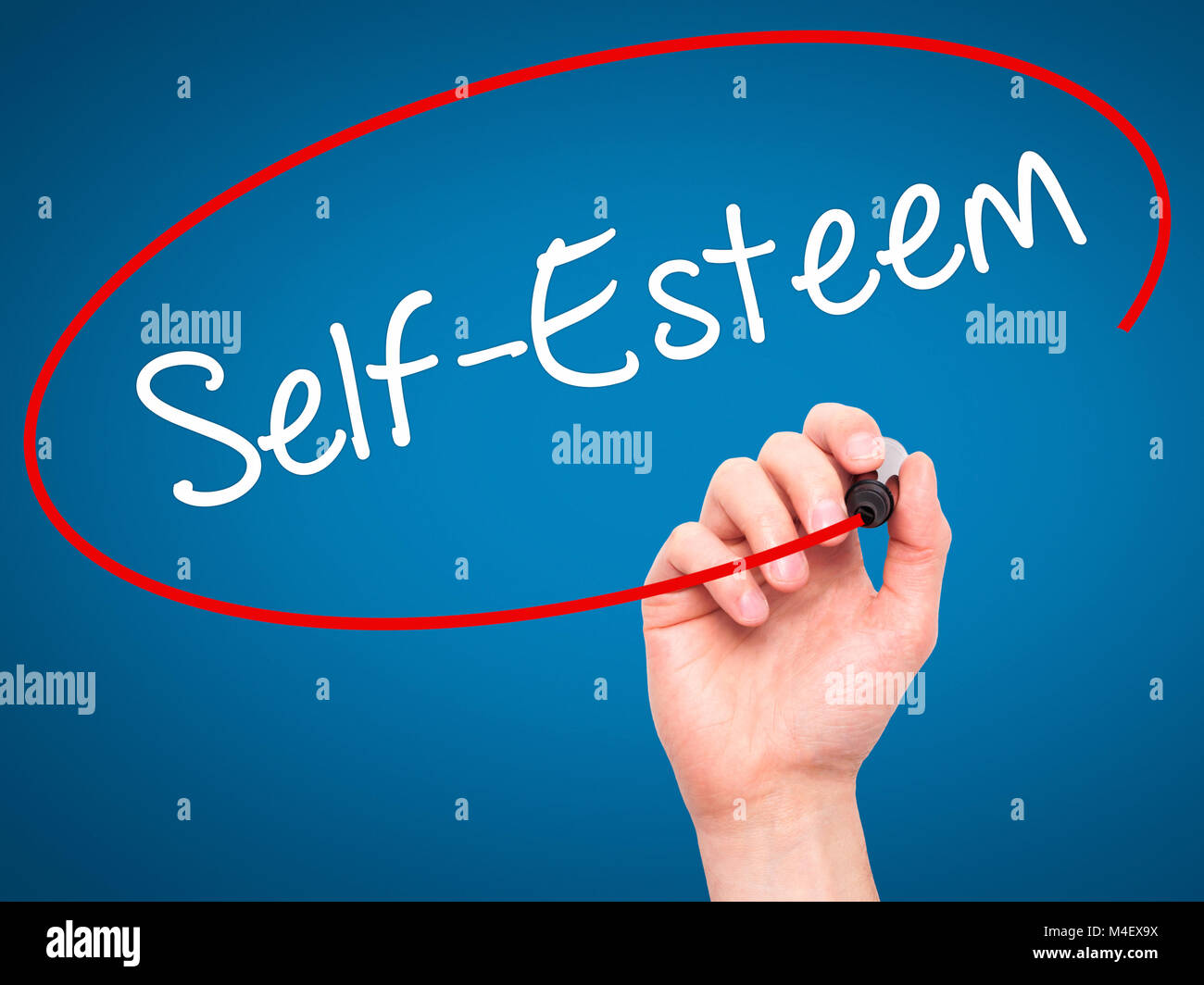 Man mano che scrive Self-Esteem con pennarello nero su schermo visivo. Foto Stock