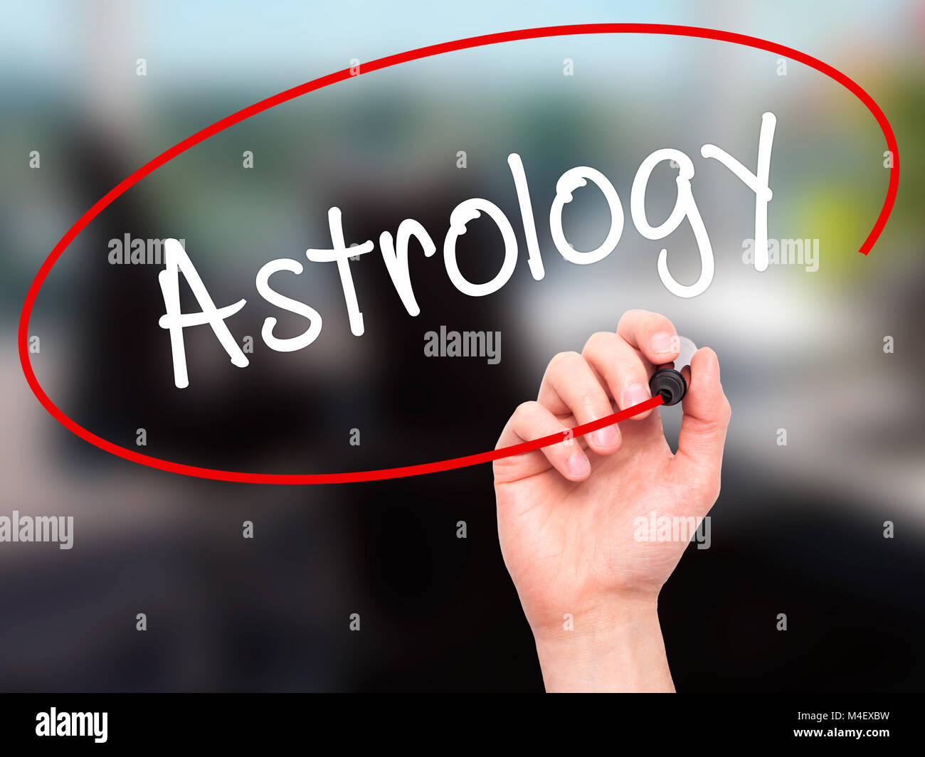 Man mano che scrive Astrologia con pennarello nero su schermo visivo Foto Stock